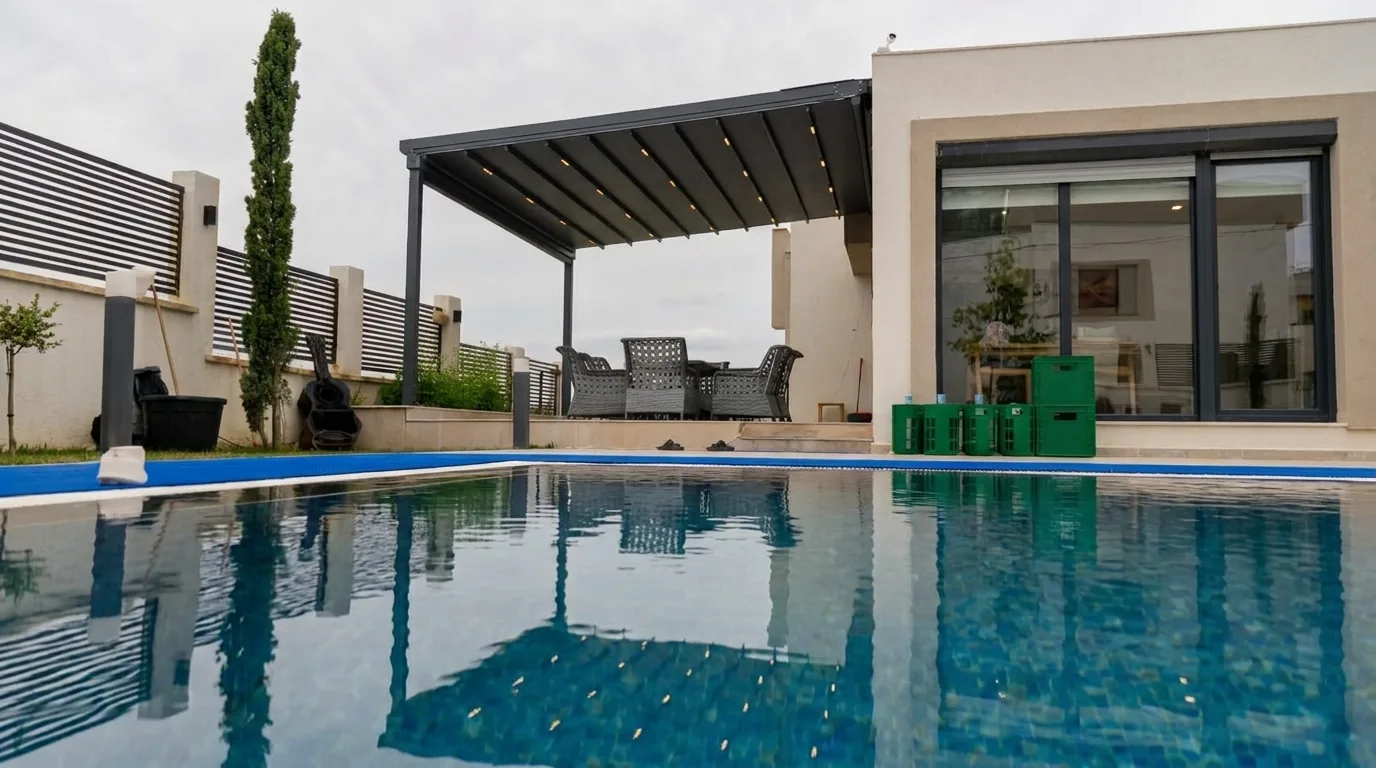 Havuz başında açılır tente pergola altında yemek alanı
